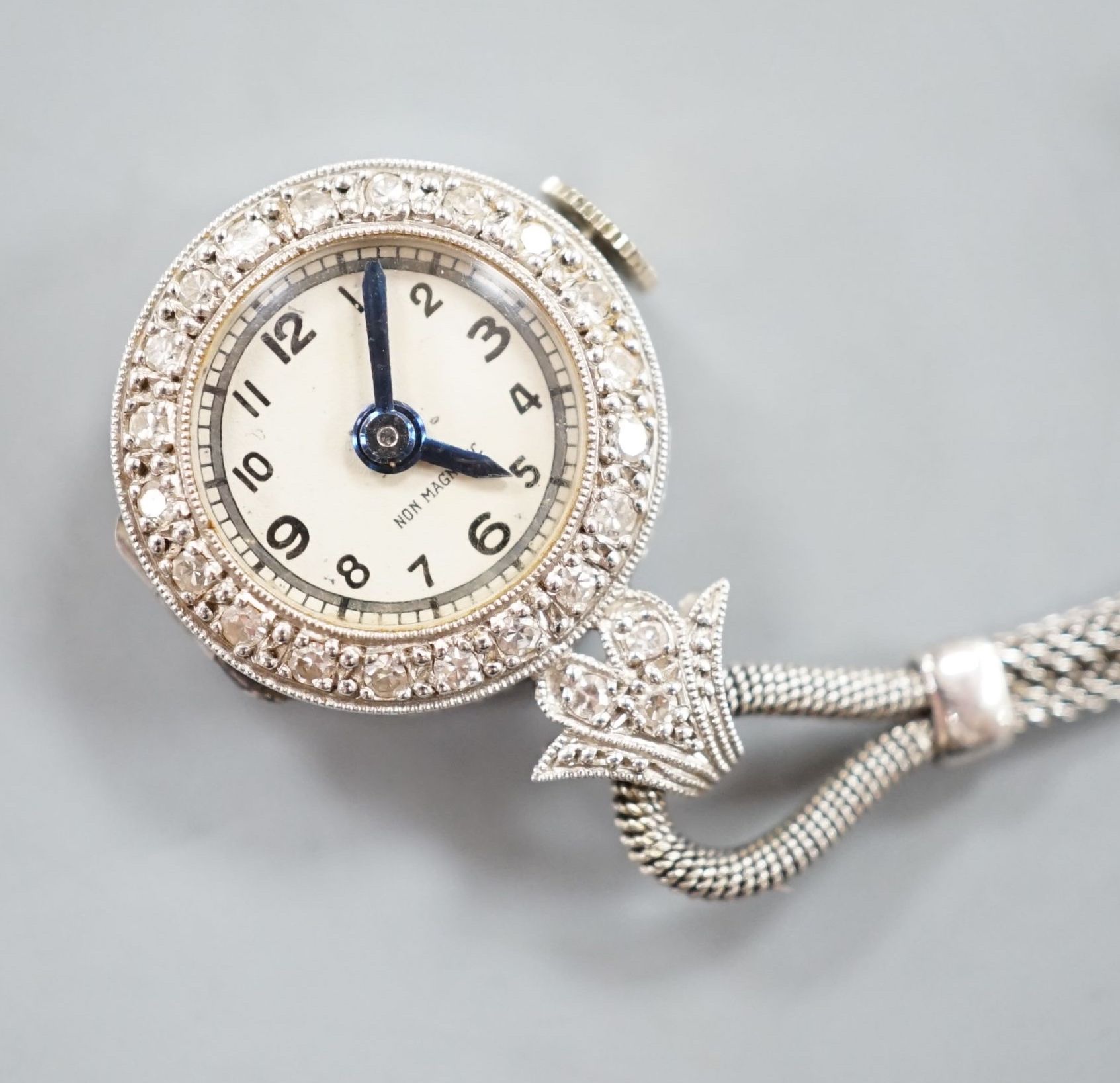 A lady's 1920's white metal (stamped platinum) and diamond chip set lapel watch, 6cm, gross weight 10.7 grams.